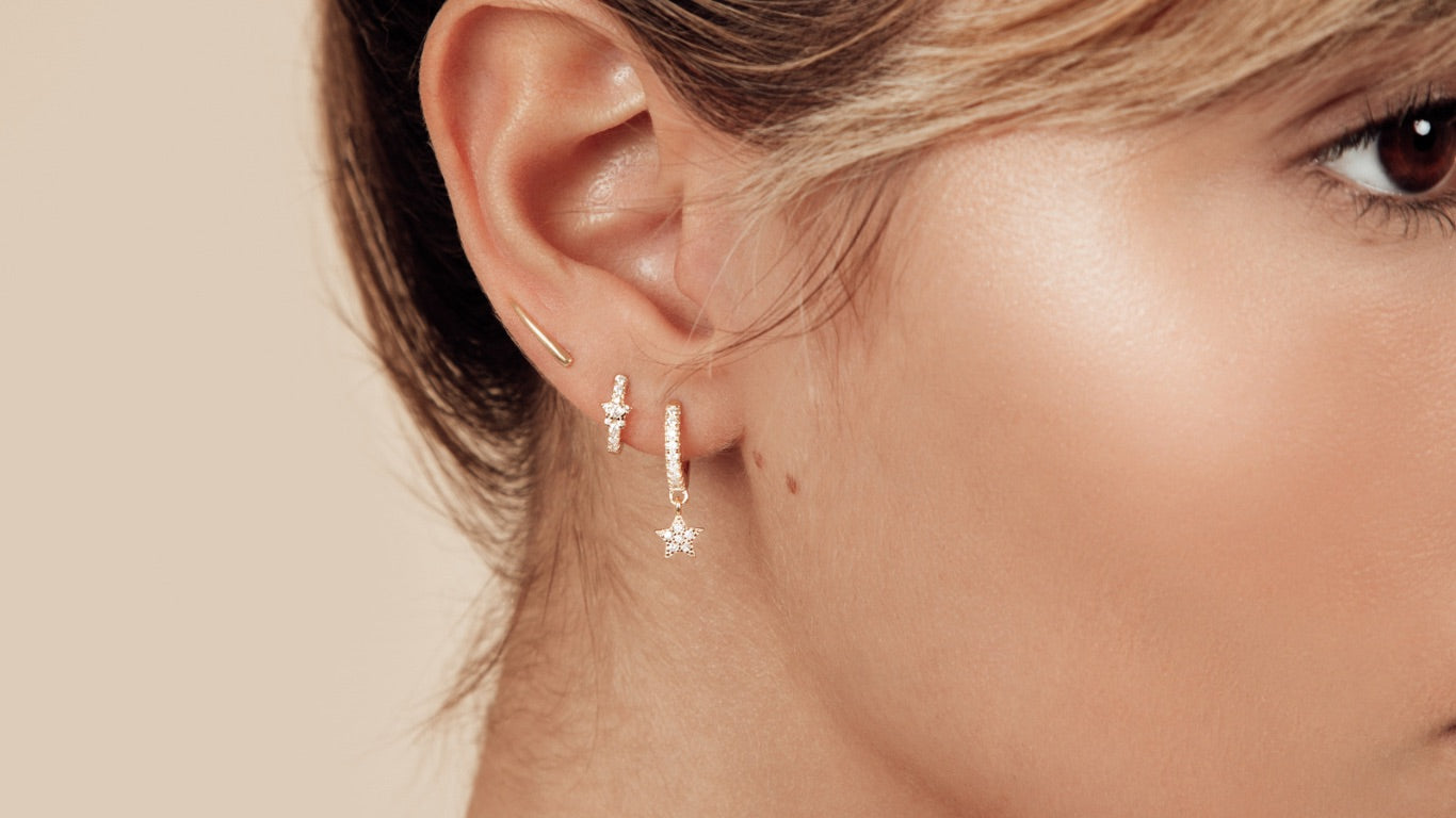 White model with three piercings and celestial earrings