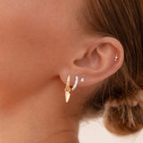 close up of ear with gold earring stack