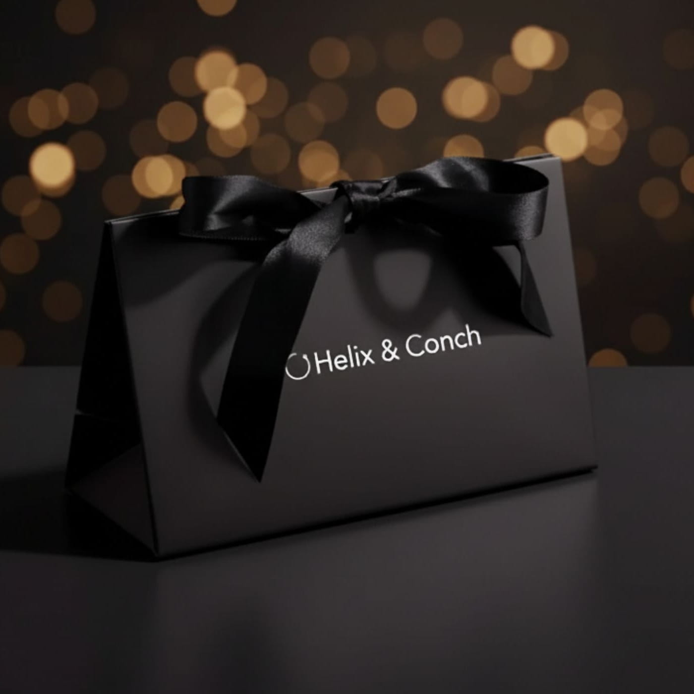 Black gift box with a bow and 'Helix & Conch' branding 