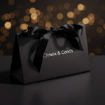 Black gift box with a bow and 'Helix & Conch' branding 