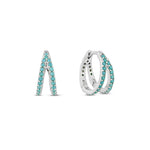 A double hoop earring with turquoise stones on a white gold plated surface, designed to give the illusion of two separate piercings.