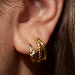 Lazo and melizza knot and illusion hoop earrings in a womans ear