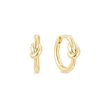 A pair of yellow gold knot huggie hoop earrings with a 14k gold plated finish on sterling silver.