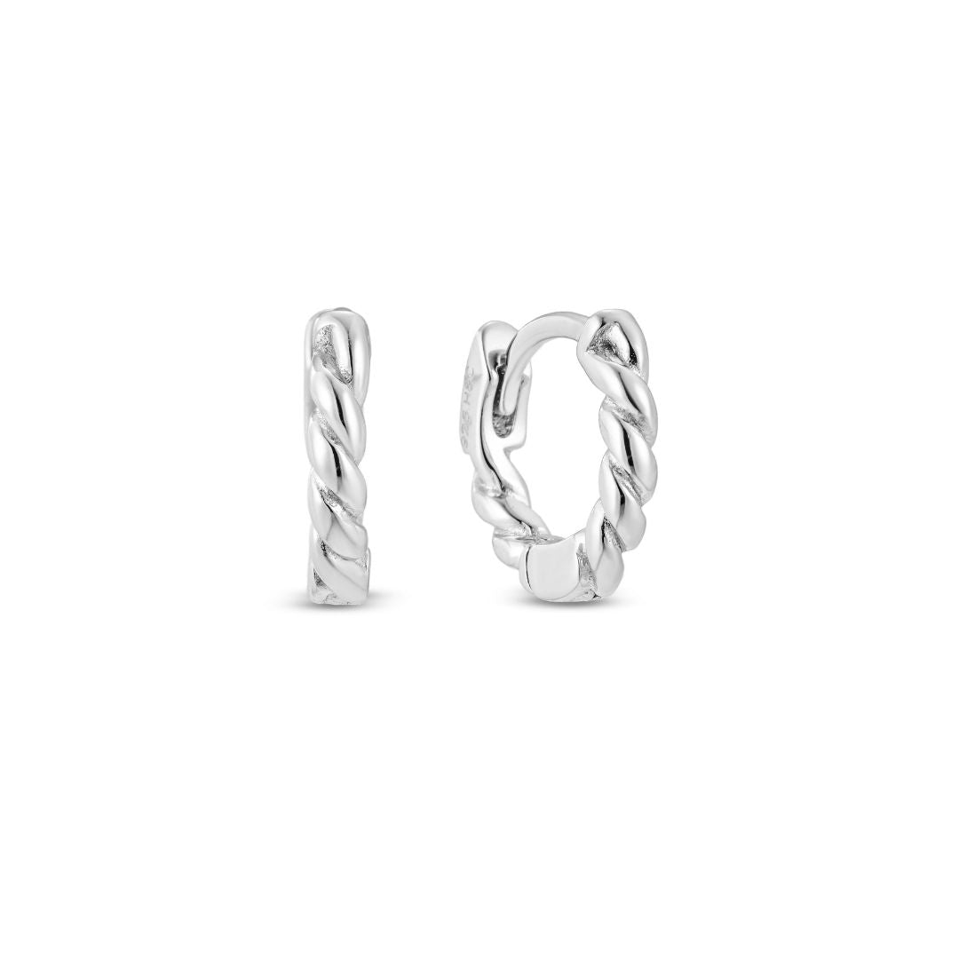 A pair of white gold rope huggie hoop earrings on a white background.