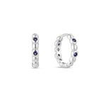 A single white gold plated hoop earring with deep blue sapphire cubic zirconia placed between white gold beading.