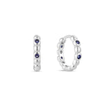 A single white gold plated hoop earring with deep blue sapphire cubic zirconia placed between white gold beading.