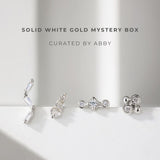 Solid white gold earrings on a light gray background with text 'Solid White Gold Mystery Box Curated by Abby'.