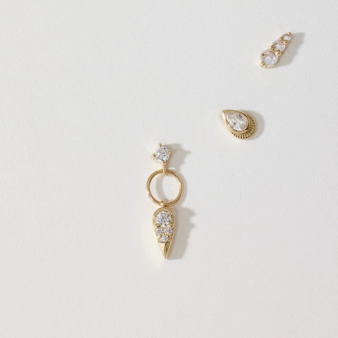 Flat Back gold earrings on pieces of paper