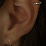 Close-up of an ear with a silver earring.